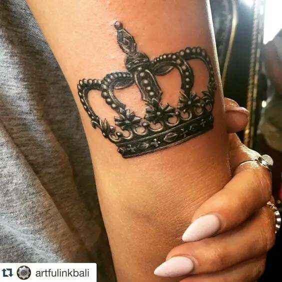 Women crown tattoo on arm