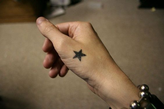 Small star tattoo on hand