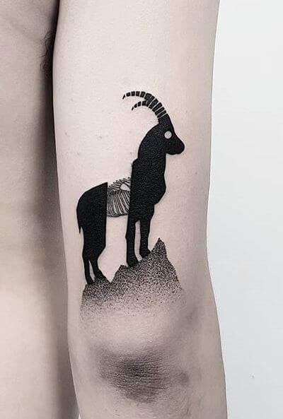goat tattoo on mountain